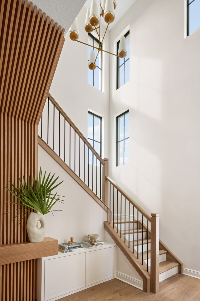 Neutral U-shaped couch, sleek circular coffee table featuring gold accents adn earth-inspired greenery