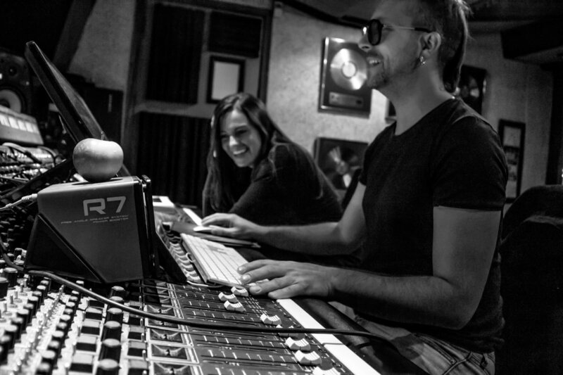 Producer working in music studio with singer-songwriter
