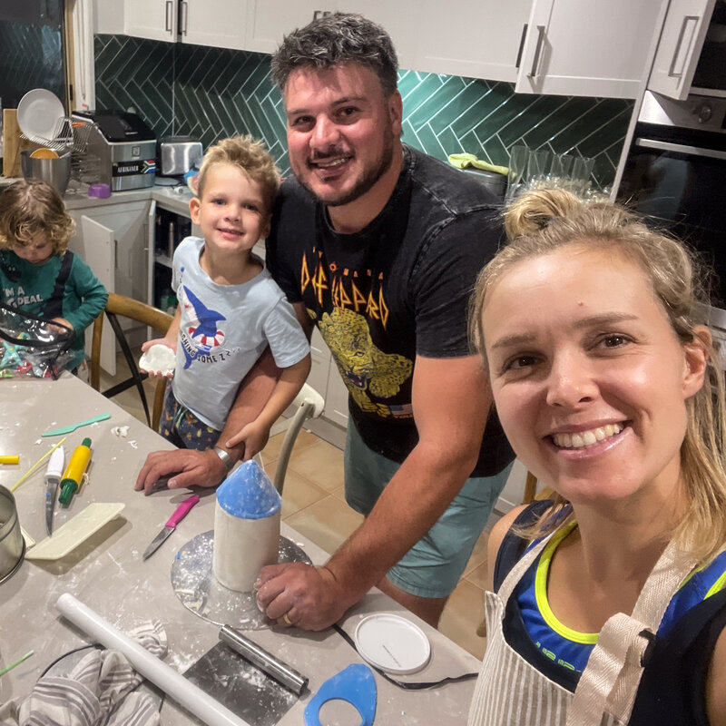 A family of 4 sharing a emotion-filled moment while they are baking a cake together in a kitchen in Bendigo. 