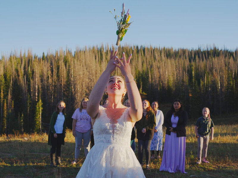 Captivating photograph capturing the exhilarating moment of a bride throwing her bouquet in the Yosemite forest, blending natural beauty with wedding tradition.
