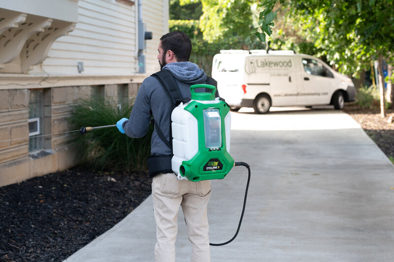 man spraying exterior of home, branding photo session