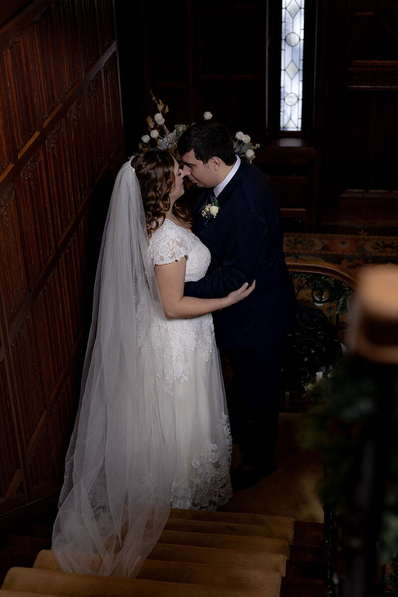 A newly married couple share a personal moment on the stairs of an old fashioned mansion in Akron, Ohio