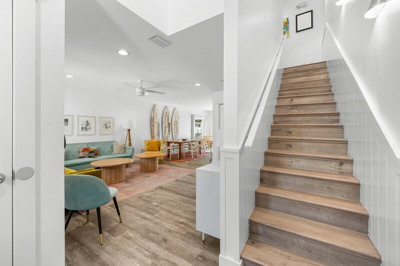 Bright and welcoming entryway of the Surf House leading into a stylish open-concept living and dining area with coastal decor.