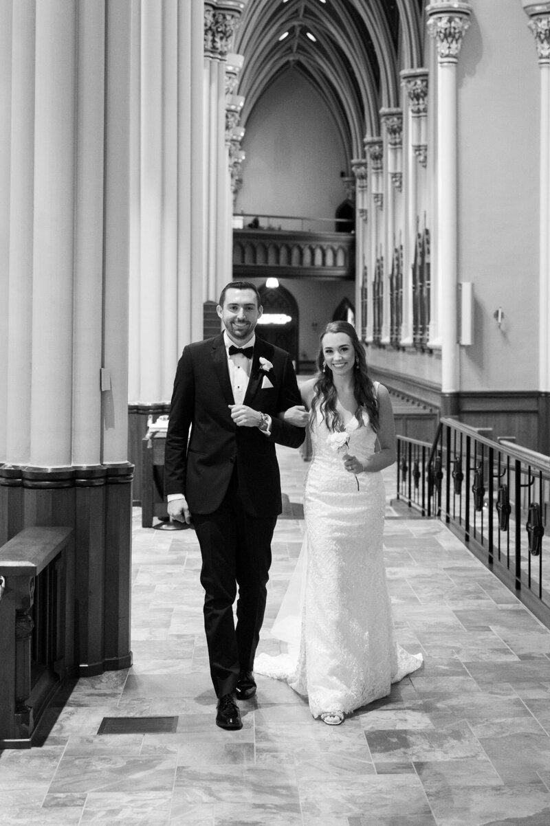 Bride and groom walking in Notre Dame Basilica