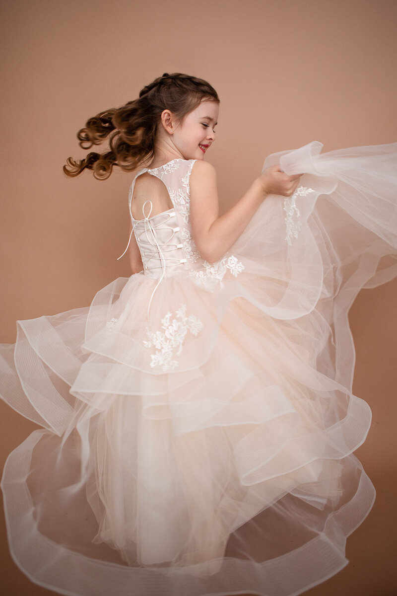 Little girl spinning in a long white dress