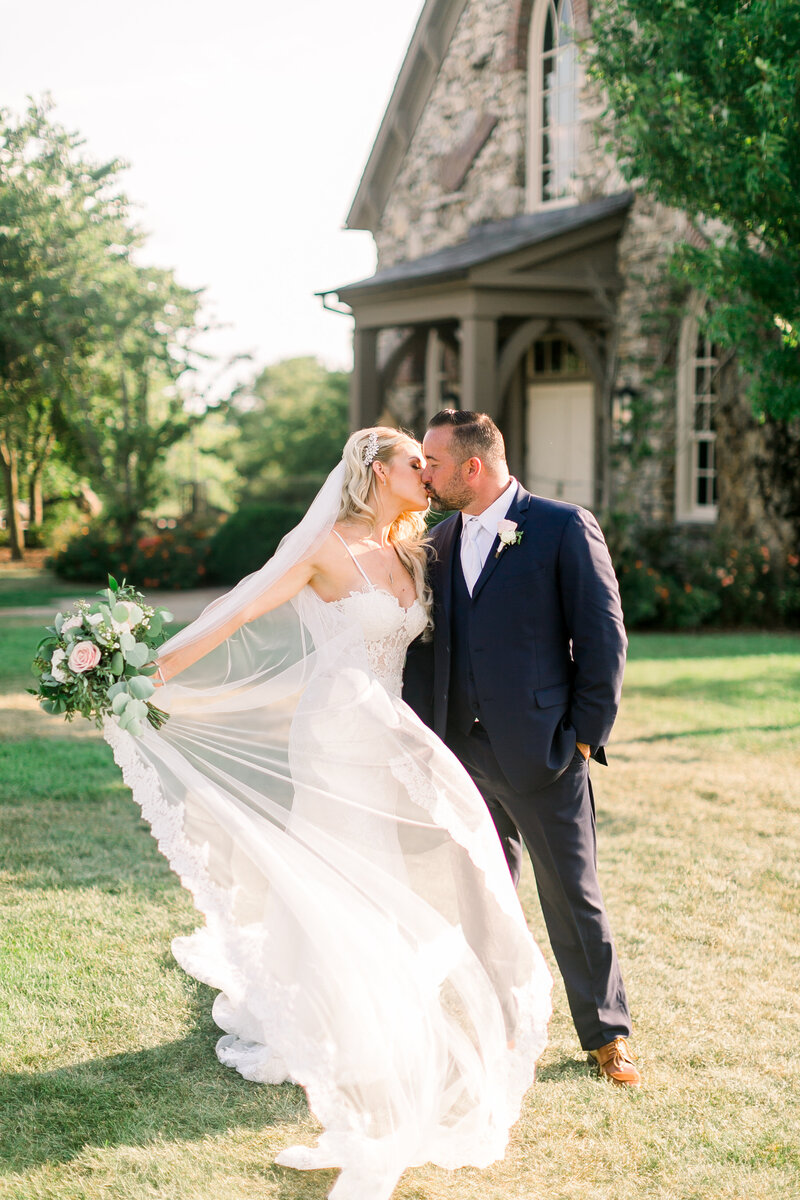 bride-with-veil-over-her-face-smiling-wearing-lace-off-the shoulder-wedding-dress-and-jeweled-bridal-hair-piece-at-integrity-hills-wedding-at-big-cedar-lodge-by-branson-wedding-photographer-kathryn-faye-photography