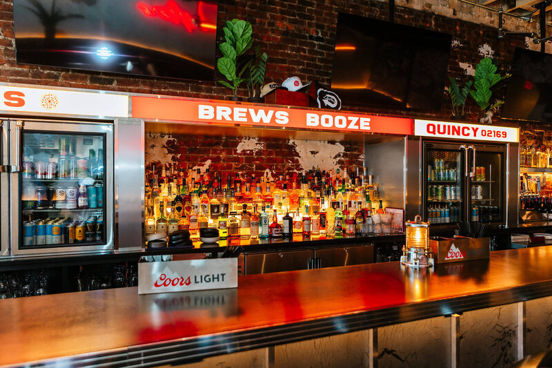 view of Drifter's bar with beer coolers framing the liquor selection under retro decor