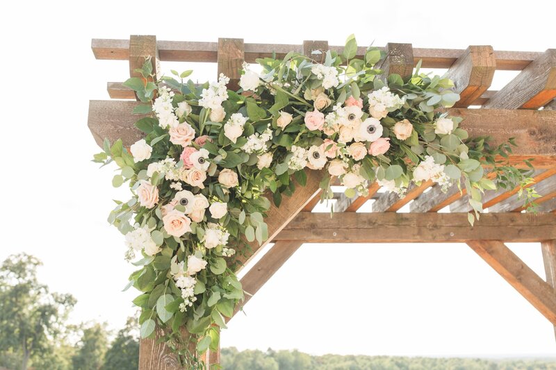flowers attached to the corner of a wooden arch