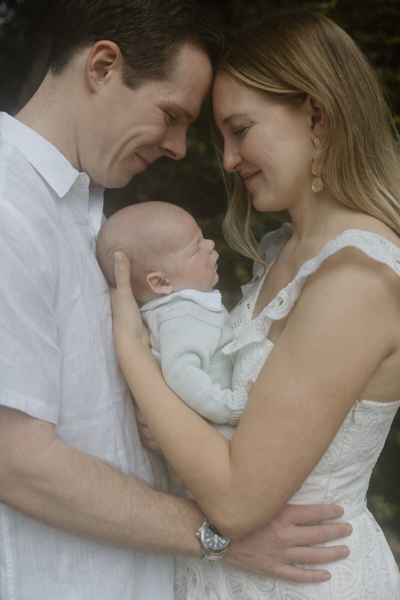 cristina pelino's portfolio image of couple holding their newborn in south florida