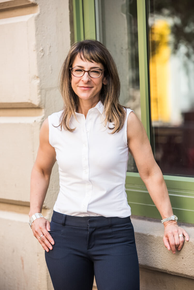 A person resting her hand on a windowsill and smiling