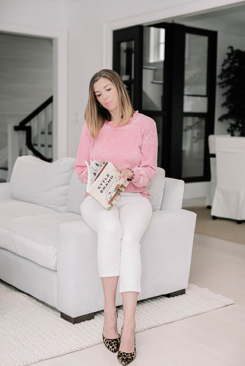 Behind-the-scenes image of Casey flipping through a design book—your go-to Canva expert for creating professional, downloadable brand templates.