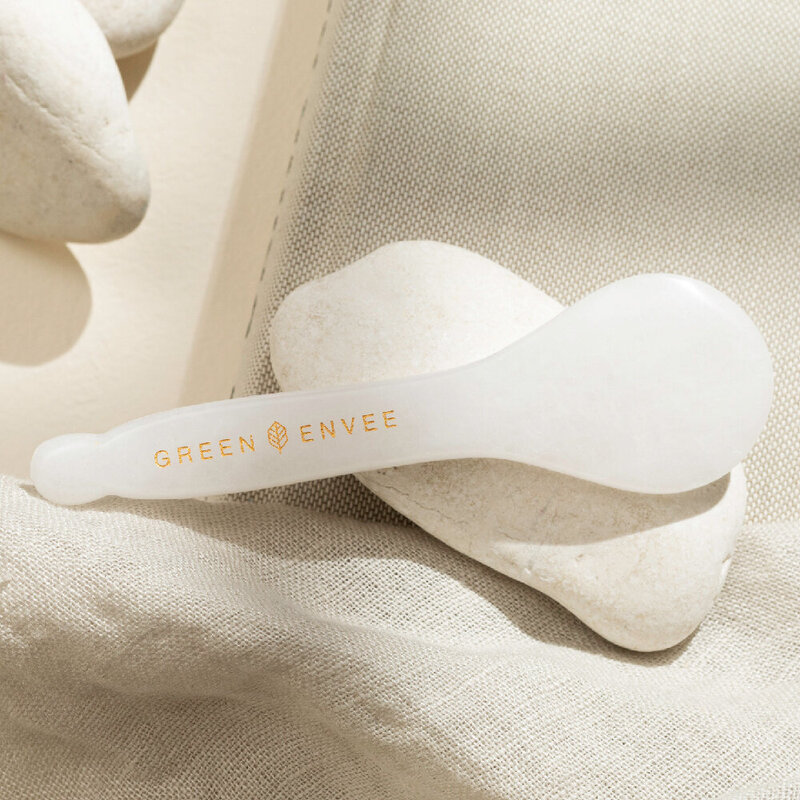 Close-up photo of white jade gua shas used in facial treatments.