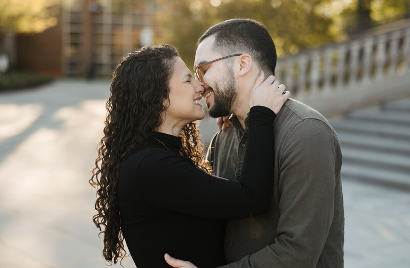 Fiance Smiling at camera while guy puts forhead against her temple