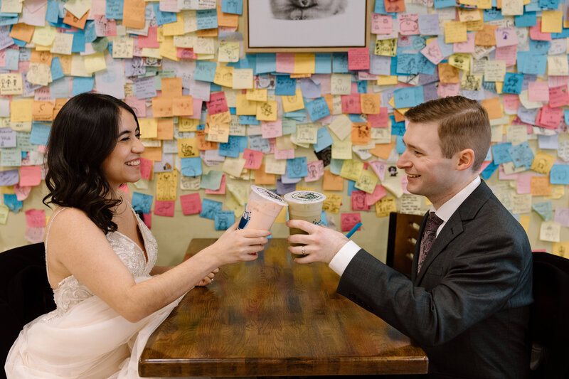 Bride and groom sitting on a bench in the Akron Art Museum with a gallery of paintings behind them. 