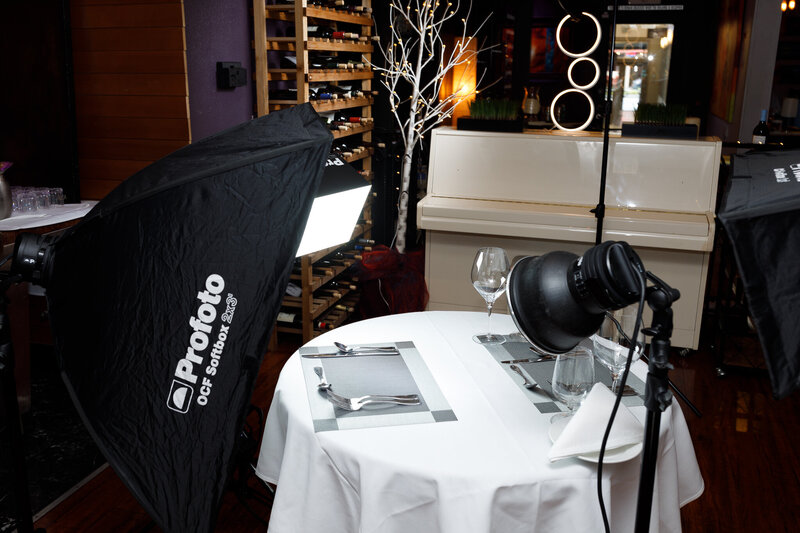 Restaurant table set ready for food photography with camera gear and lighting