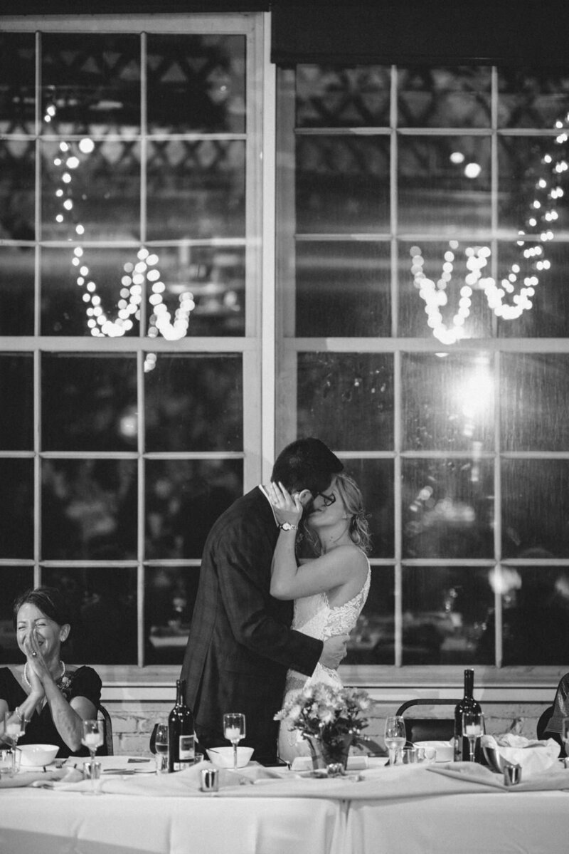 Jolie photo d’inspiration capturant les mariés qui s’embrassent tendrement pendant la réception à l’Espace Shawinigan en Mauricie, moment chaleureux et authentique d’un mariage célébré avec émotion
