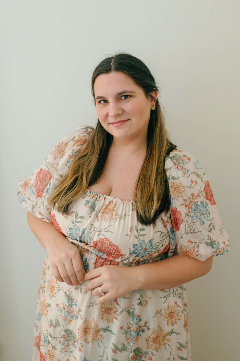 Rachael Mattio, a Virginia wedding photographer, smiling in a floral dress, captured in a relaxed and friendly portrait