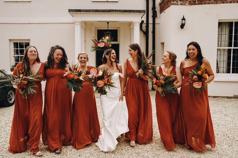 bridesmaids in terracotta dresses with bride