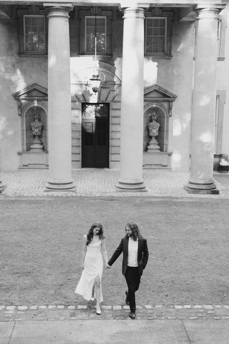 Bride and groom walk together outside the european columns of the Swan House in Atlanta