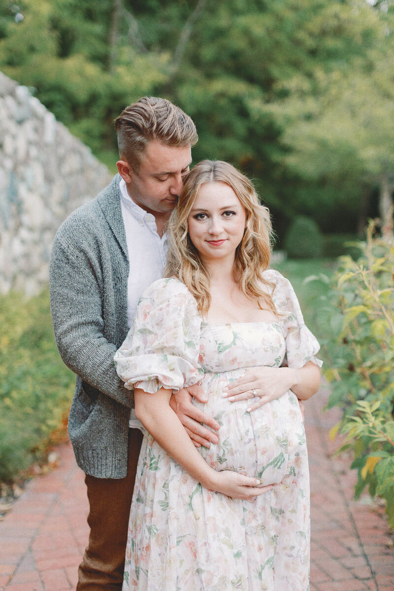 husband embracing his pregnant wife