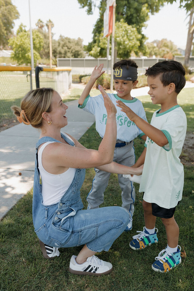 coach giving a hive five to kids at camp