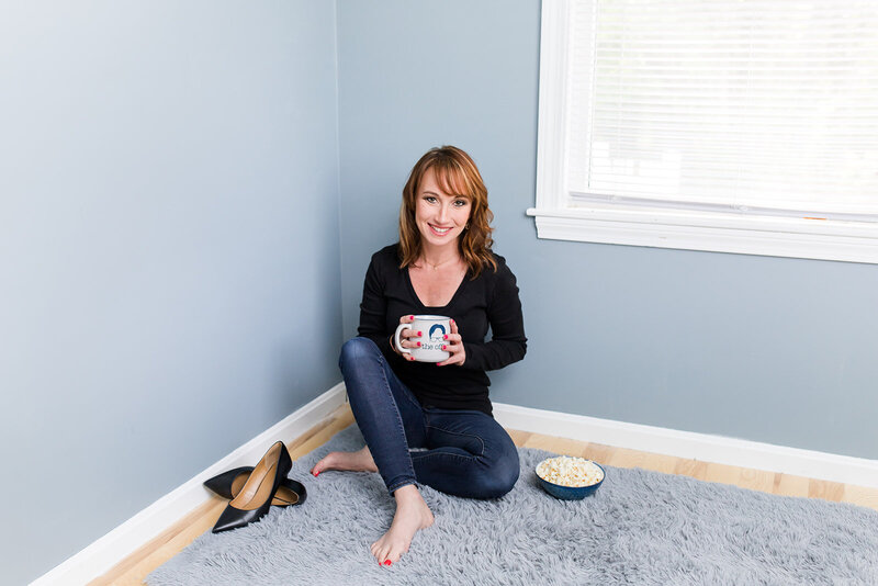 Showit designer holding coffee while sitting on the ground
