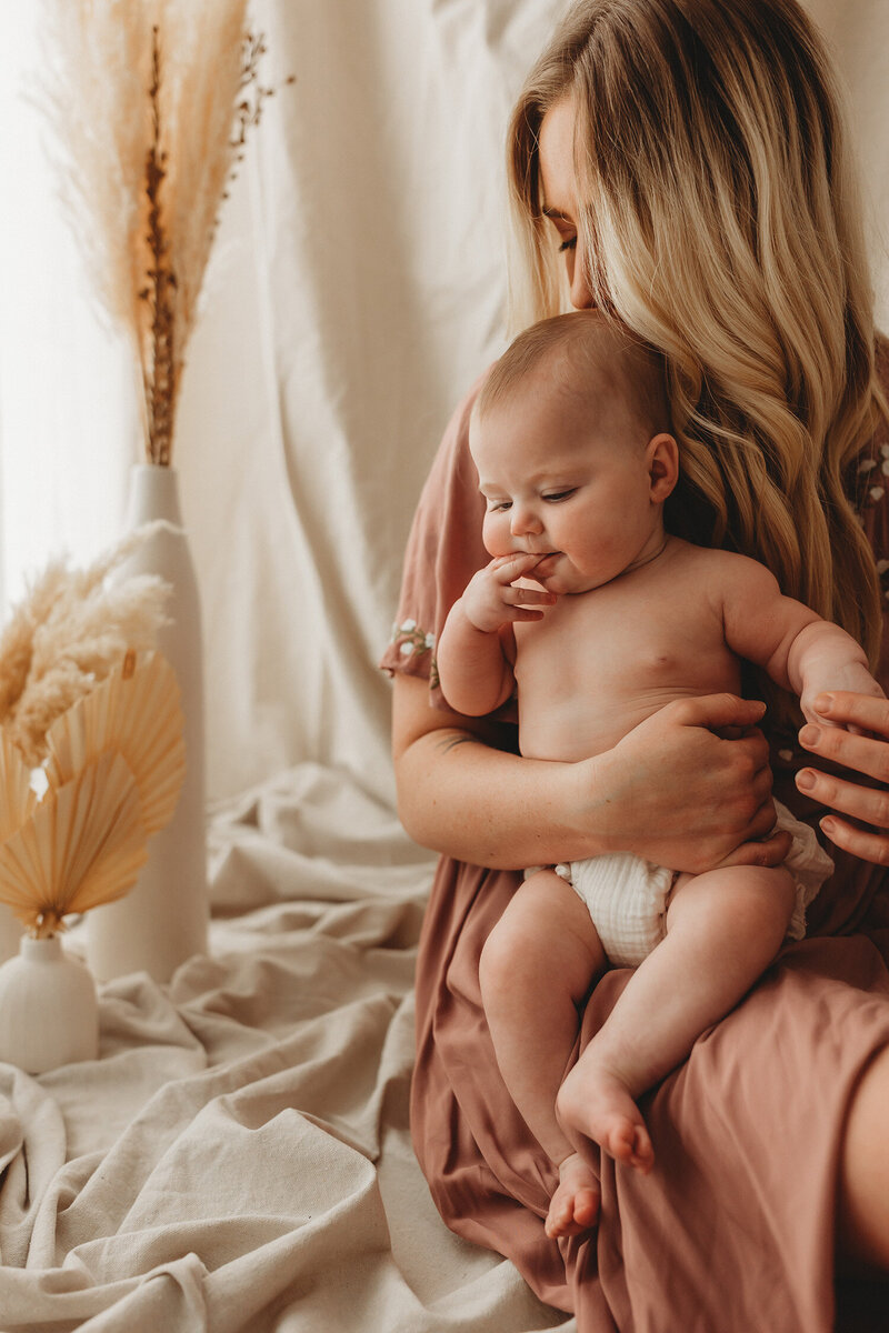 Studio family portrait of mother holding baby  kissing it's head