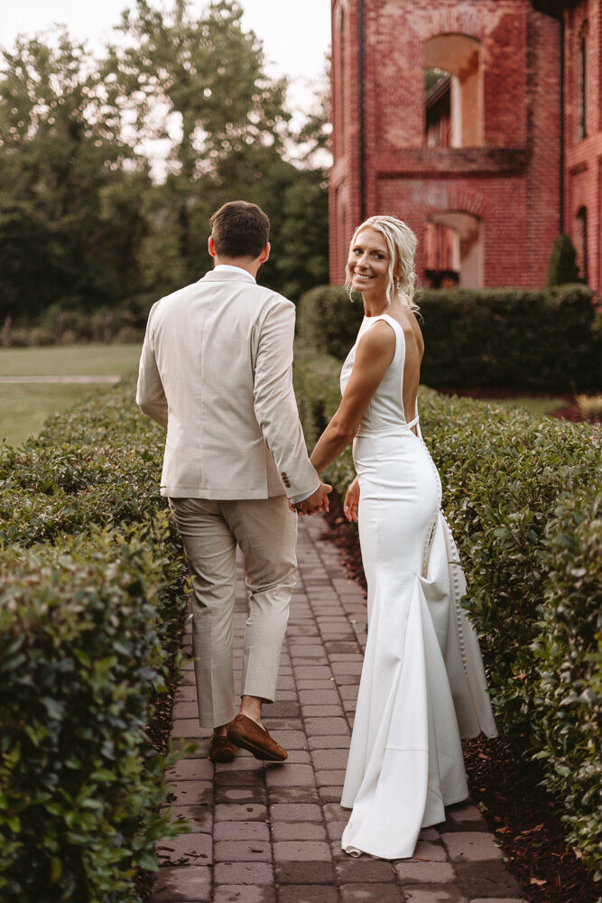 bride walking and looking back with hands held
