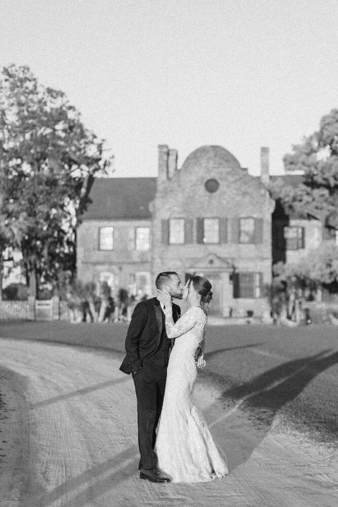 married couple kissing in front of venue