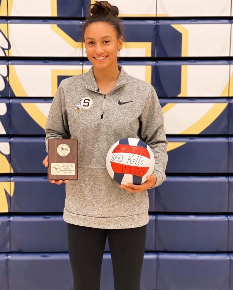 Grace holding her plaque and volleyball