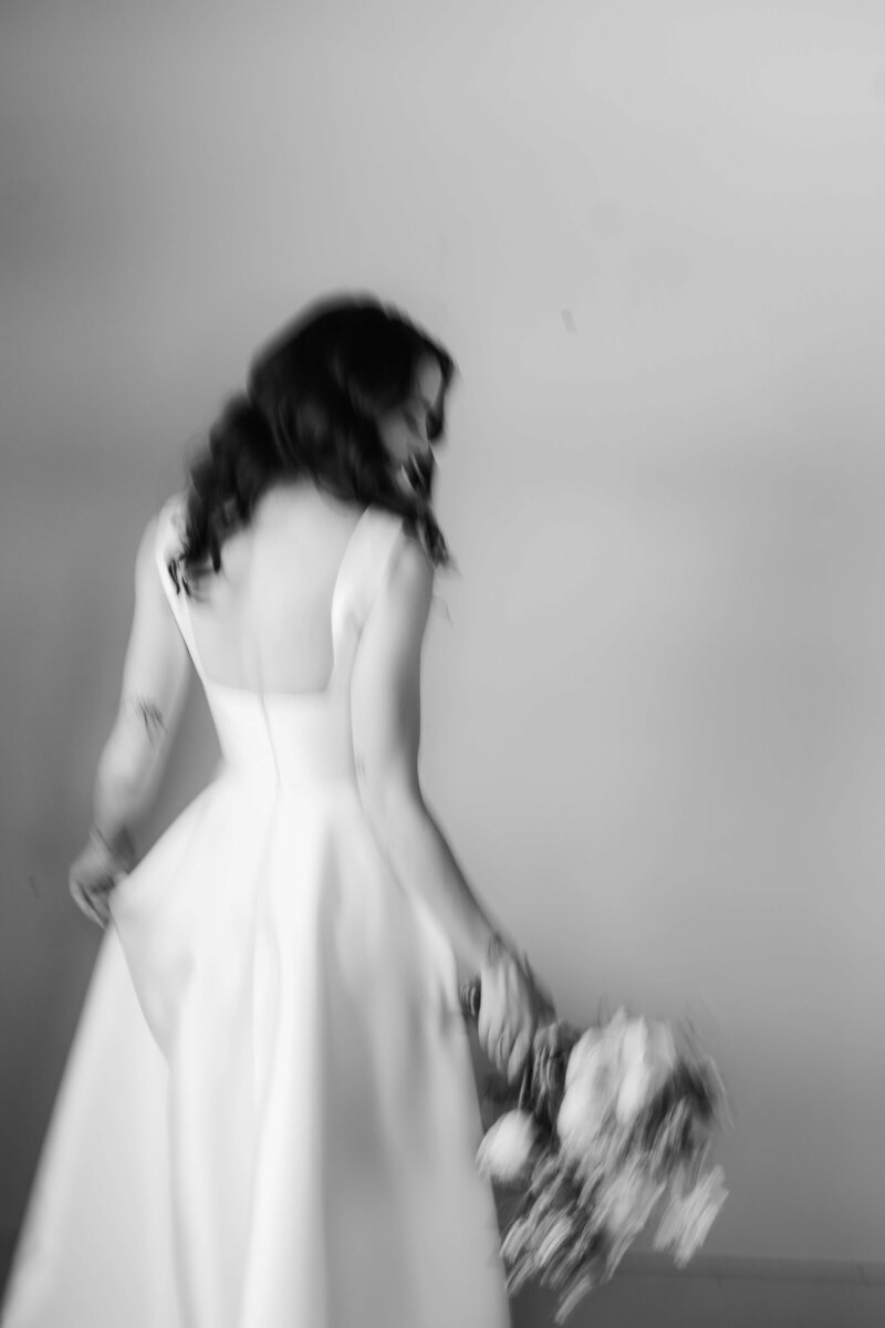 Black and white photo of a mother fixing brides dress