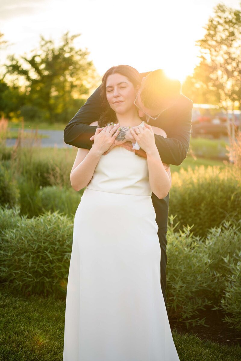 Bride and Groom Embrace during outside wedding during sunset