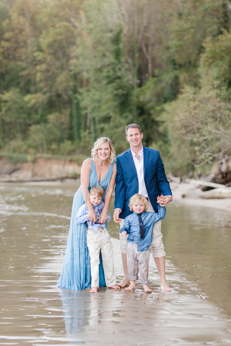 family portrait standing in a creek