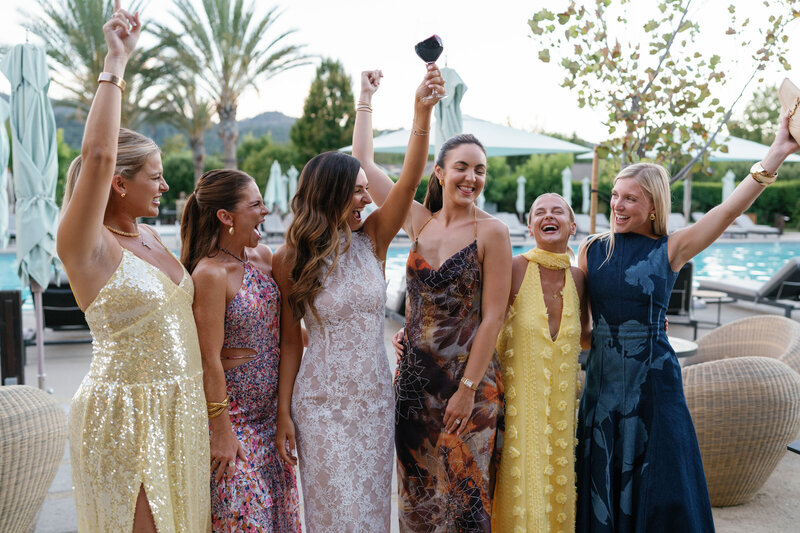 A black-and-white close-up of a place setting with a floral-illustrated menu, layered plates, and a glowing candle.
