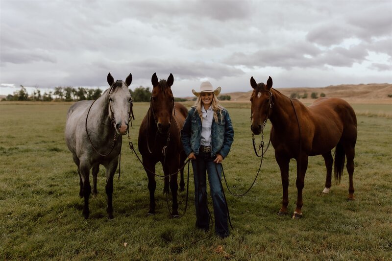 Senior portrait session in Wyoming, featuring a high school senior with horses in a rustic outdoor setting, capturing a free-spirited and natural moment.