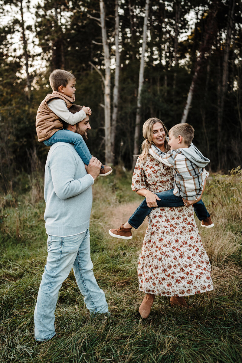 Two young brothers in teddy bear pajamas hugging outside.