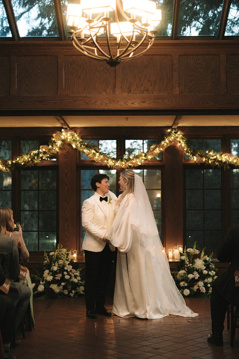 Two grooms posing in front of venue