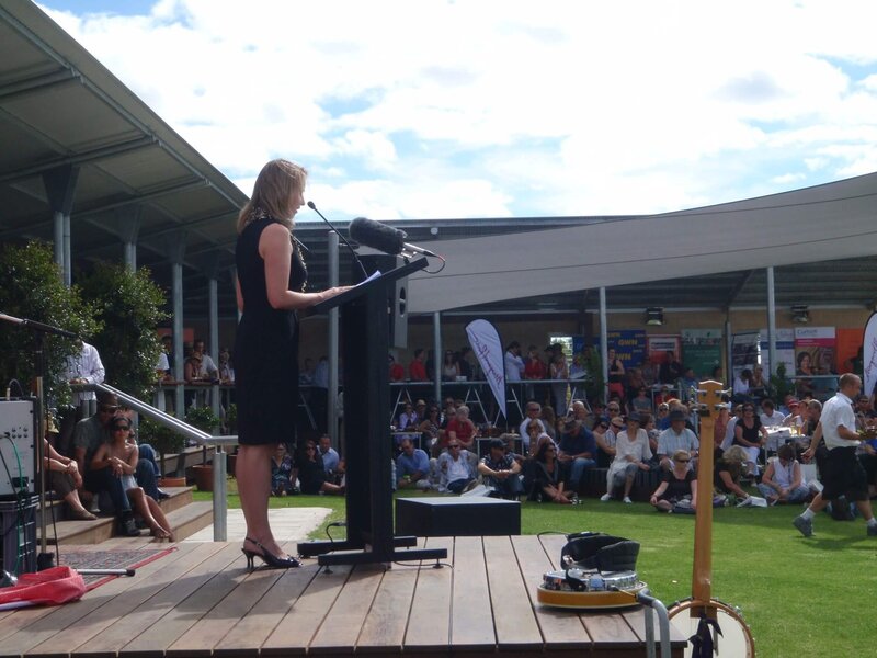 Francine speaking at podium to crowd at an outdoor event