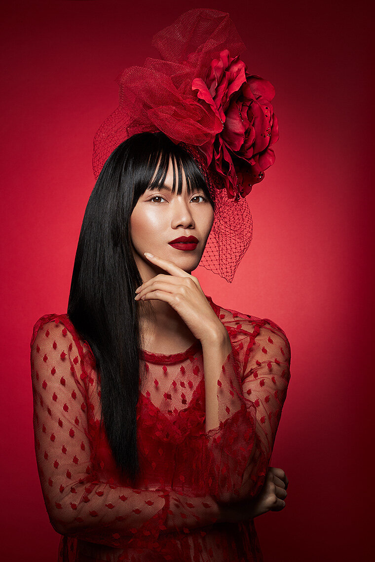 Moody portrait of Darin in a red outfit with lace details and bold makeup, captured by Ylva Erevall.