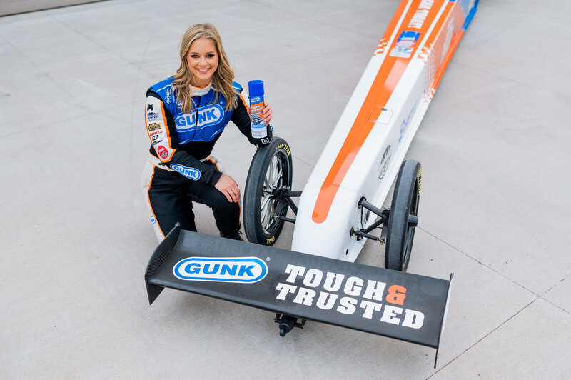megan meyer crouching next to race car