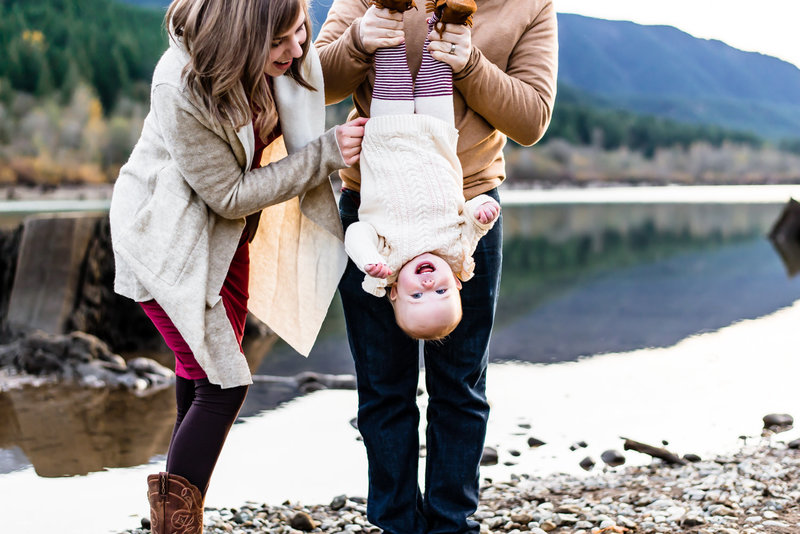 Family in sweaters holding baby upside-down at Rattlesnake Lake