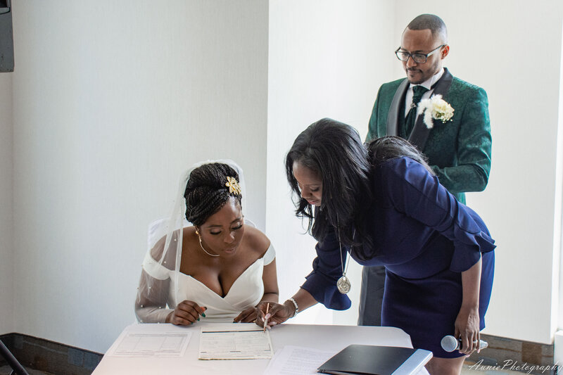 Bride signing document with officiant