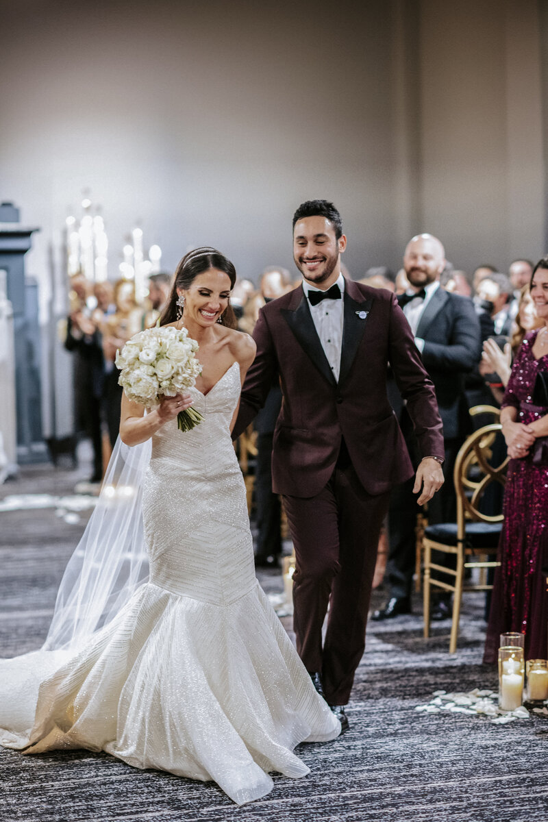 gleeful-couple-walking-down-wedding-aisle-in-modern-ceremony-setting