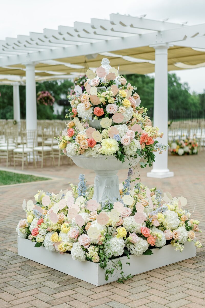 Large outdoor floral arrangement in pastel tones for a wedding ceremony