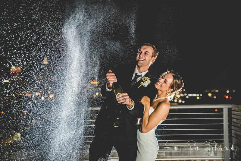 bride and groom popping a bottle of champagne