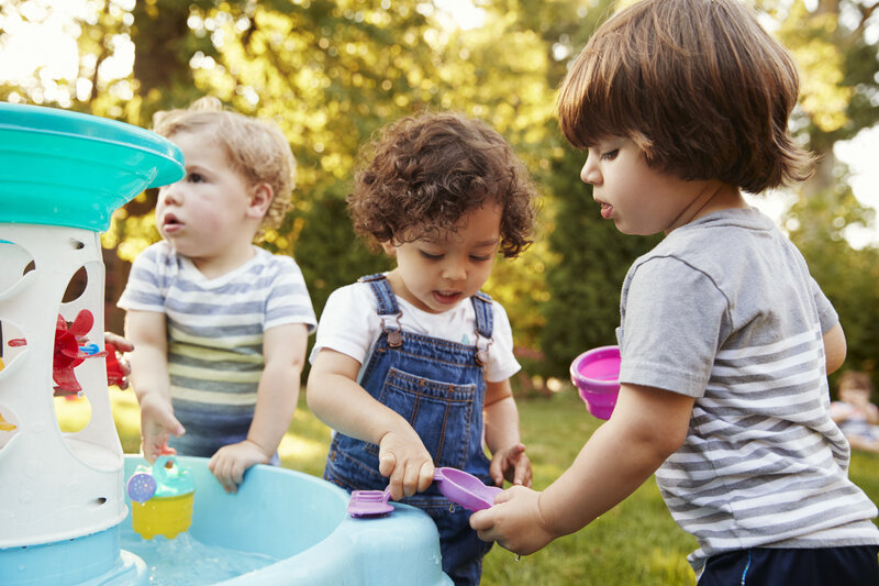 Children playing with a water toy station outside