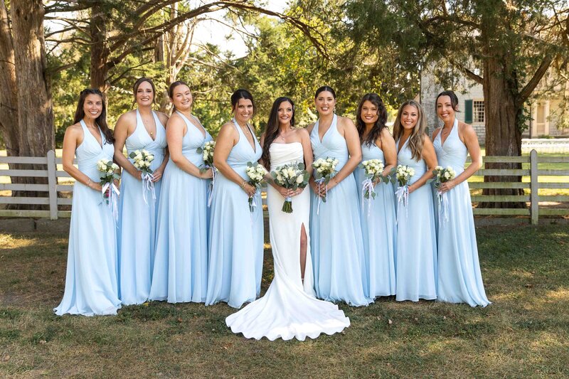 bride standing with bridesmaids while they all smile