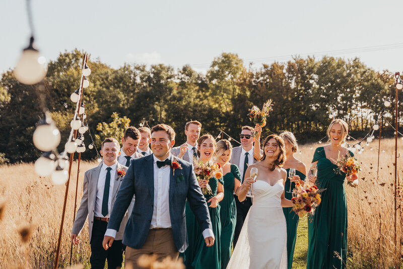 wedding party celebrate whilst walking towards camera