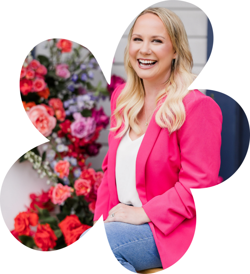 Founder of Bloom Bar posing in front of vibrant floral wall, embodying bold brand identity and Austin floral design creativity.