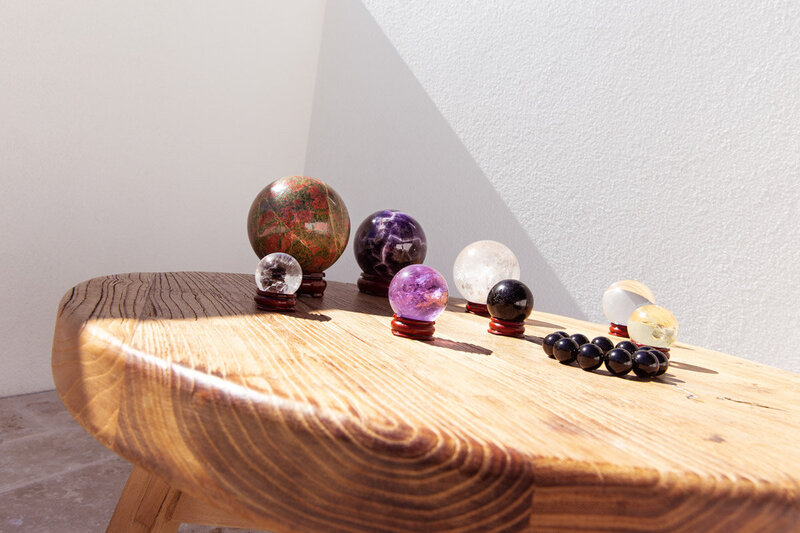 A range of crystal spheres - our chi balls - on a rustic table bathed in soft light.